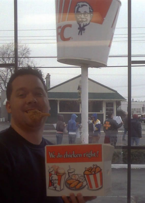 Joe posing with lunch (protestors in background)